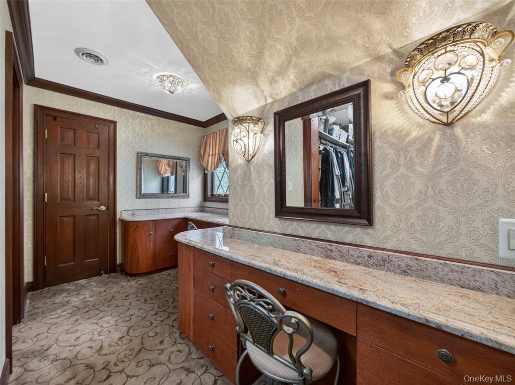 Primary suite dressing room with built-in cabinetry